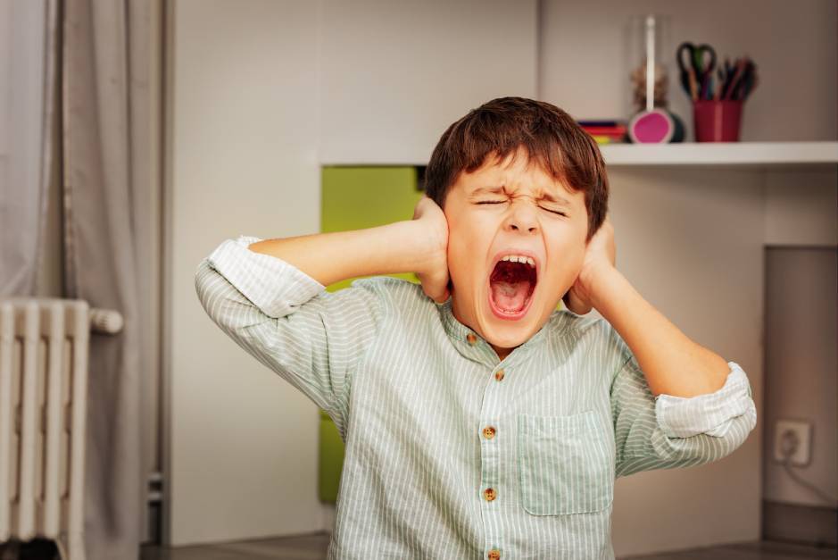 SkyClimb Method, child covering ears and screaming showing sensory overload and emotional dysregulation behaviors.