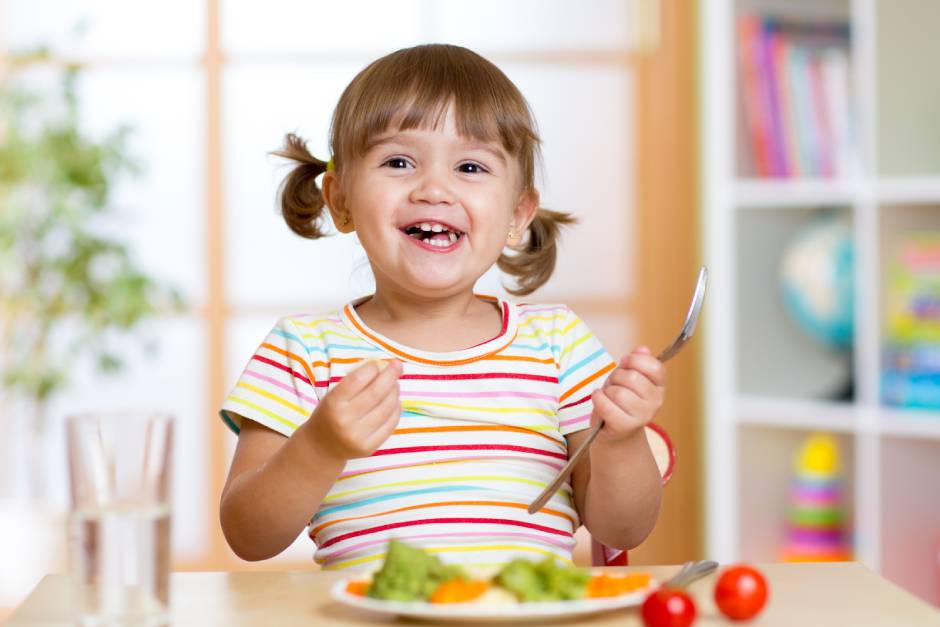 SkyClimb Method, happy toddler girl eating healthy vegetables demonstrating positive mealtime behaviors and nutrition habits
